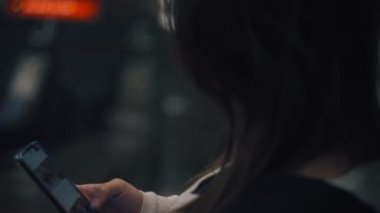 Yürüyen merdivende akıllı telefon kullanan bir kadın.