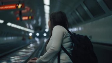 Yürüyen merdivende giden kadın.