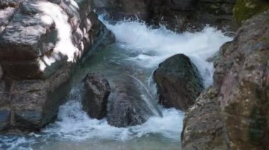 Büyük kayaların arasından akan vahşi dağ nehri. Yavaş çekim. 