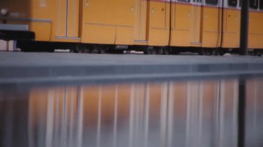Hareket halindeki tramvay şehrin çeşme suyu yüzeyine yansıyor. Yavaş çekim.