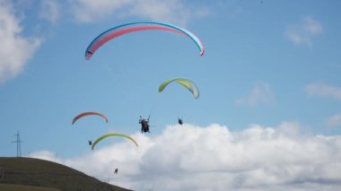 Gudauri, Gürcistan - 27 Eylül 2021: Dağ tepesinde süzülen bir grup paraşütçü. 