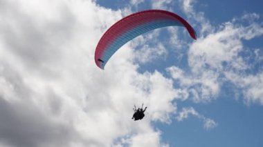 Gudauri, Georgia - 27 Eylül 2021: Gökyüzü altında yamaç paraşütü yapan turist ve eğitmen