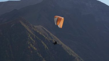 Gudauri, Gürcistan - 27 Eylül 2021: Dağ yamacının yanında yamaç paraşütü yapan turist ve eğitmen