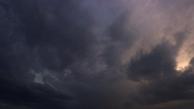 Gün batımında gri bulutların arkasında güzel güneş ışınları beliriyor. Bulutlu zaman çizelgesi. 