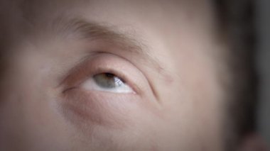 Bir erkeğin gözünü kapat ve yukarı bak. Yavaş çekim, yüzeysel alan derinliği. 