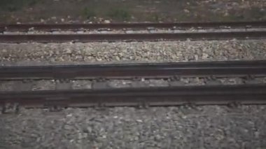 Çakıl taşları üzerinde tren raylarının pencere görünümü. 