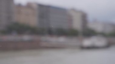 Bulanık şehir arka planında yağmur damlaları. Yavaş çekim. 