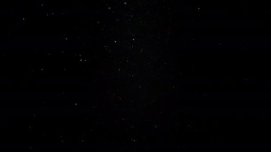 Siyah arka planda havada süzülen toz parçacıkları. Yavaş çekim. 