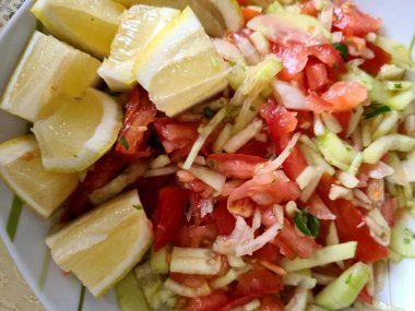 Salatalık dilimleri, kiraz domatesleri, limon dilimleri, biber ve tuz karışımı ile vejetaryen kasesi. Sağlıklı ve diyet için besin. 