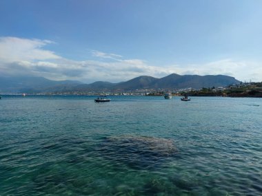 Akdeniz kıyısında deniz manzarası ve arka planda dağlar