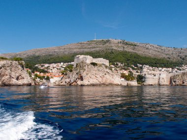 Eski şehrin kayalık kıyılarının güzel manzarası. Arka planda mavi bir gökyüzü ve deniz manzarası var.