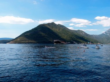Arka planda mavi gökyüzü ve dağlar olan körfezin güzel manzarası.