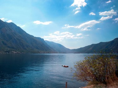 Arka planda mavi gökyüzü ve dağlar olan körfezin güzel manzarası.