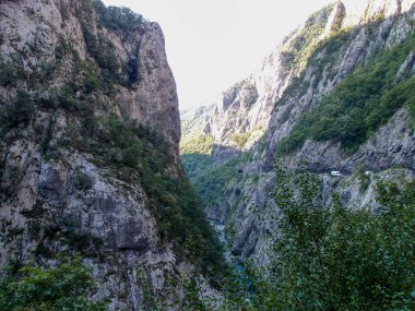 Manzaralı dağ manzarası, dağlık nehir kanyonu manzarası orman, yeşil ağaçlar, dağlar ve mavi gökyüzü.