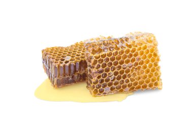 Two pieces of beeswax with honey and spilled honey on a white background