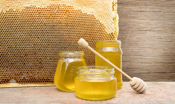 Background of three jars of honey on the background of a bee frame with copy space
