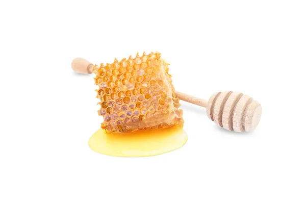 a piece of beeswax on a white background and a honey stick nearby