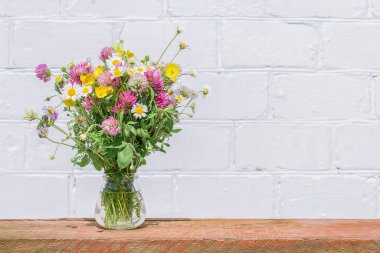 Decor from a bouquet of wild flowers on a white wall background