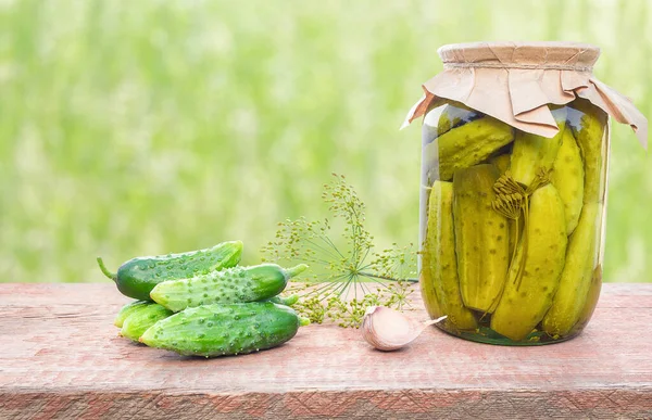 Ingredients for preservation and a jar of pickled cucumbers