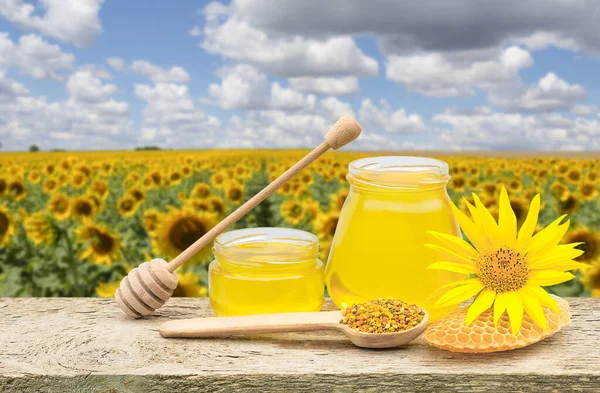 A jar of honey on the background of a sunflower field