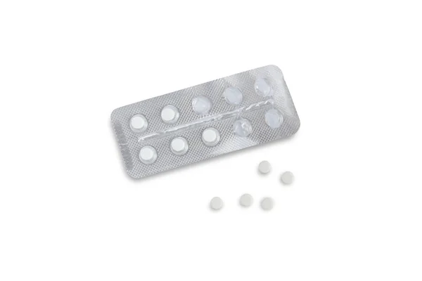 An open blister with tablets and five tablets nearby