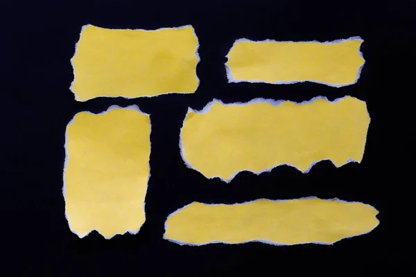 Five yellow pieces of paper for writing information on a black background
