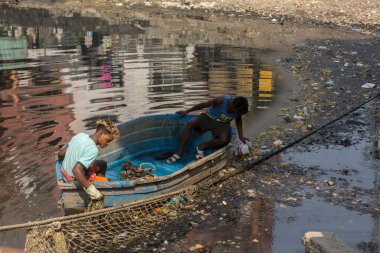 19 Kasım 2021, Kolkata, Batı Bengal, Hindistan: Teknede iki kişi Kolkata, Hindistan 'da çıplak elleriyle çöpleri temizlemeye çalışıyor.