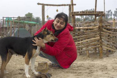 Kumsalda sevimli bir köpekle eğlenen genç bir gezgin. Seçici odak.