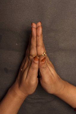 Hoş geldin işareti gösteren bir kadın eli ya da namaskar ya da namaste elleriyle ve seçici bir dikkatle..