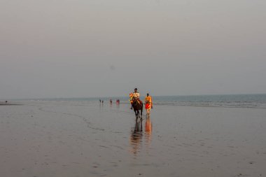 2 Şubat 2022, Digha, Batı Bengal, Hindistan: Gün batımında ata binen iki genç at binicisi.