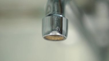 Musluktan damlayan bir damla saf su. Su kaynaklarını kullanarak. Musluğu kapayın. Makro çekim