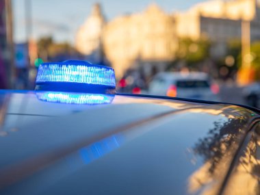 Polis arabasının tepesindeki mavi ışıklar. Arka plan bulanık. Işıklar da bokeh etkisi yapıyor.