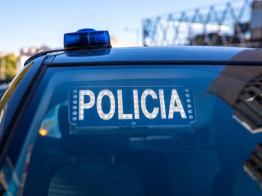 Polis arabasının tepesindeki mavi ışıklar. Arka plan bulanık. Işıklar da bokeh etkisi yapıyor.