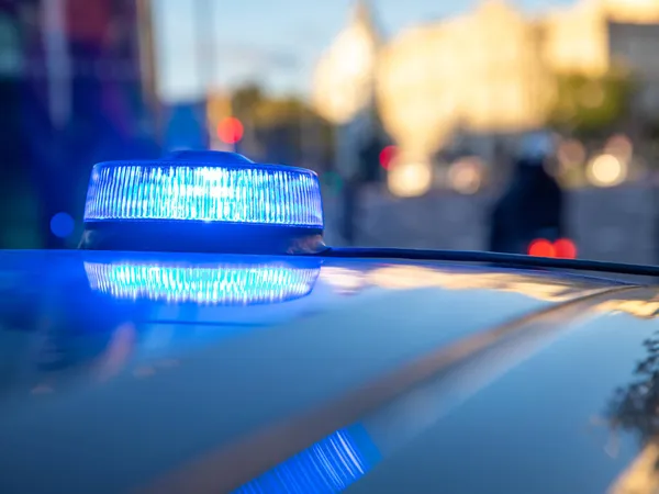 Polis arabasının tepesindeki mavi ışıklar. Arka plan bulanık. Işıklar da bokeh etkisi yapıyor.
