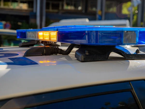 Polis arabasının tepesindeki mavi ışıklar. Arka plan bulanık. Işıklar da bokeh etkisi yapıyor.