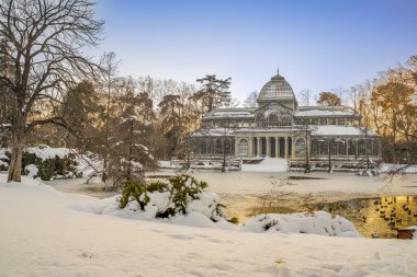 Yoğun bir kar yağışından sonra, gün batımında Retiro Park 'taki Kristal Saray