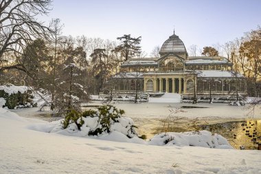 Yoğun bir kar yağışından sonra, gün batımında Retiro Park 'taki Kristal Saray