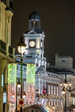 Christmas in Puerta del Sol, in the city of Madrid with lighting and typical decoration, with the clock and christmas tree