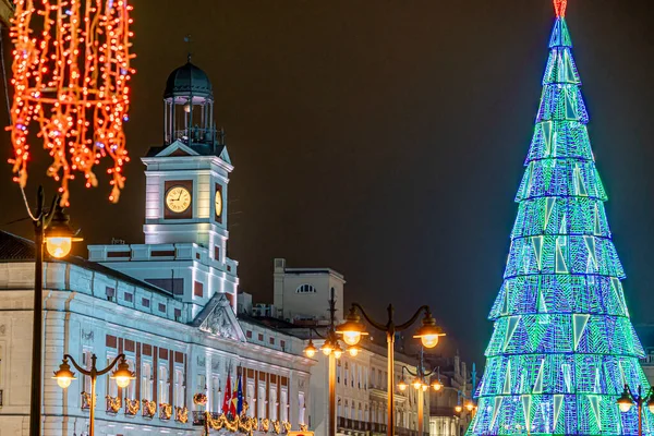 Christmas in Puerta del Sol, in the city of Madrid with lighting and typical decoration, with the clock and christmas tree