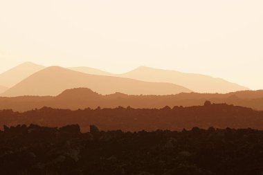 Turuncu tabakalı volkanik bir manzara.