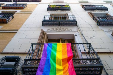 Madrid 'deki Chueca mahallesinin önünde homoseksüel gururu temsil eden bir gökkuşağı bayrağı ve LGTBI haklarının savunulması