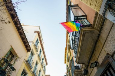Madrid 'deki Chueca mahallesinin önünde homoseksüel gururu temsil eden bir gökkuşağı bayrağı ve LGTBI haklarının savunulması