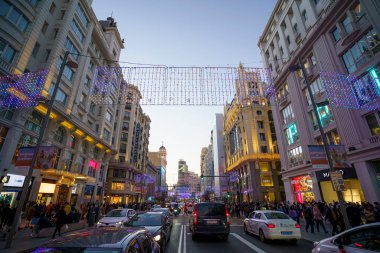 Madrid şehrinde Noel ışıkları ve trafik ile ünlü ve kalabalık Gran Va caddesi.