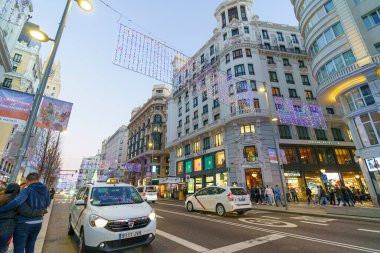 Madrid şehrinde Noel ışıkları ve trafik ile ünlü ve kalabalık Gran Va caddesi.