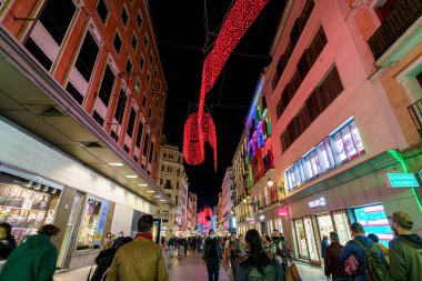 Noel boyunca Madrid 'de Noel ışıklandırması ve insanların alışveriş telaşıyla ticaret ve kalabalık Calle Preciados.