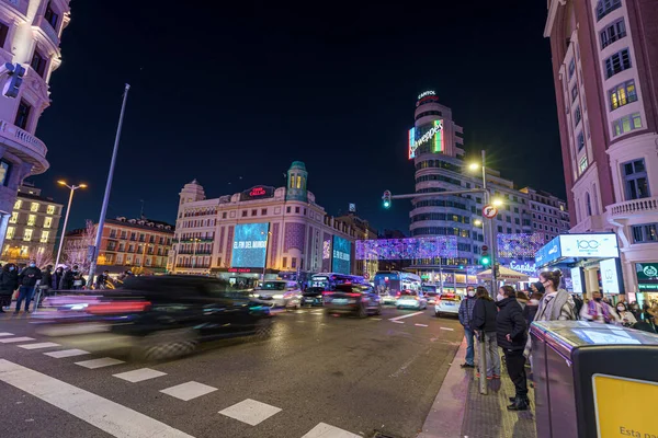 Madrid şehrinde Noel ışıkları ve trafik ile ünlü ve kalabalık Gran Va caddesi.