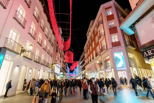 Noel boyunca Madrid 'de Noel ışıklandırması ve insanların alışveriş telaşıyla ticaret ve kalabalık Calle Preciados.