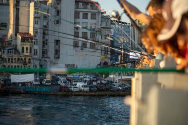 İstanbul, Türkiye 'deki Galata köprüsünde oltaları olan balıkçılar