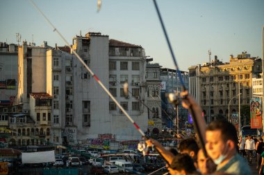 İstanbul, Türkiye 'deki Galata köprüsünde oltaları olan balıkçılar