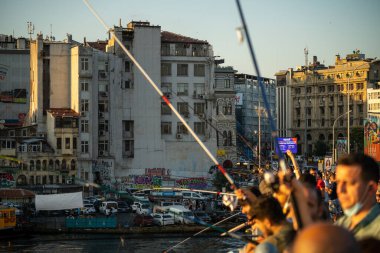 İstanbul, Türkiye 'deki Galata köprüsünde oltaları olan balıkçılar